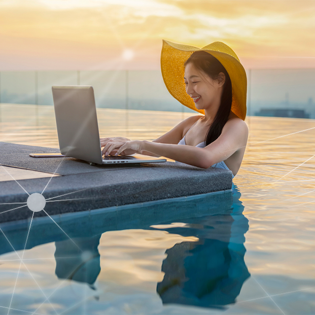 Woman in a Pool Using a Laptop