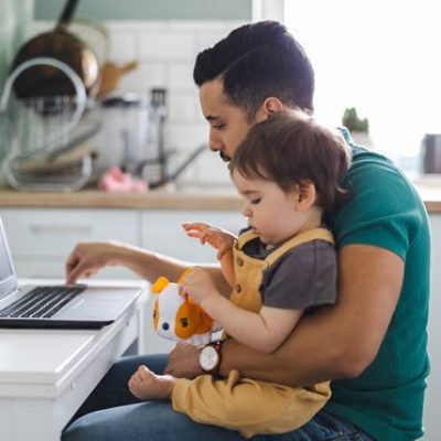 Man using AI on computer while holding his child