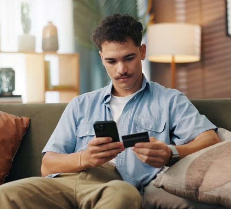 Young man makes payment over the phone with credit card
