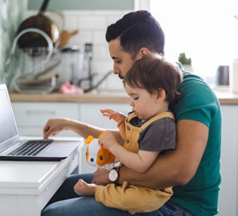 Man using AI on computer while holding his child