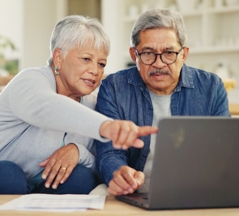 senior couple looking at their laptop